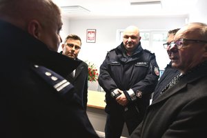 Kierownictwo policji rozmawia z gośćmi oglądającymi wnętrze posterunku