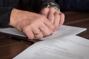 zdjęcie przedstawia mężczyznę podpisującego dokumenty