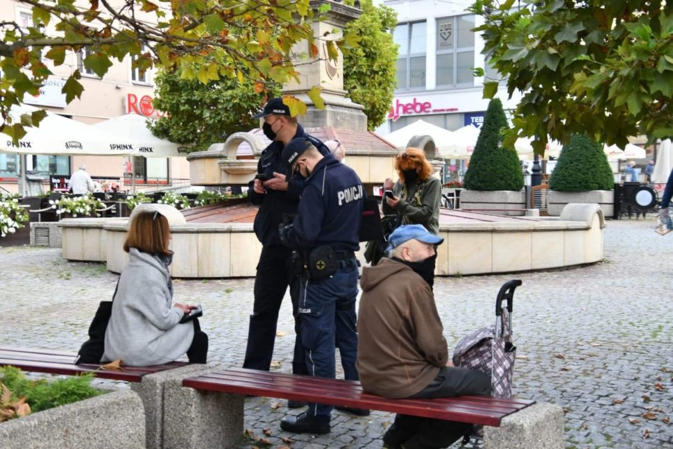 Umundurowni policjanci legitymują osobę, która lekceważy obwiązujące przepisy.