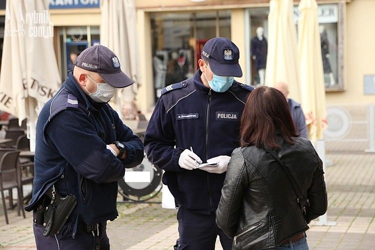 Umundurowani policjanci legitymują kobietę, która nie stosuje się do obowiązujących przepisów.