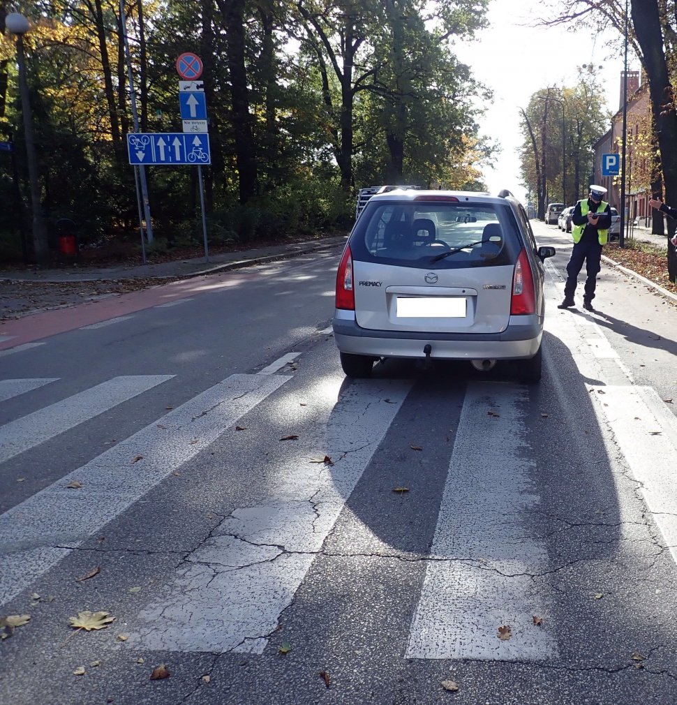 Przejście da pieszych - policjant prowadzi oględziny na miejscu potracenia 59-latki.