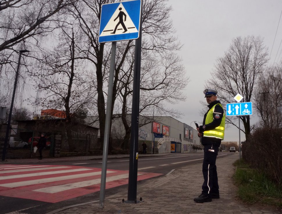 Policjant WRD rozdaje odblaski w rejonie przejścia dla pieszych