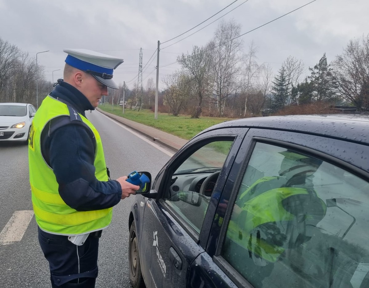 Policjant sprawdza stan trzeźwości kierującego osobówką.