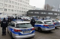 tył 3 radiowozów. w tle prezydent z policjantami