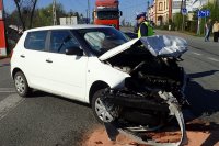 skoda ze zniszczonym przodem. obok stoi policjant