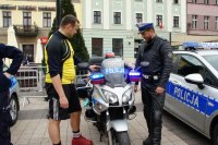 dziecko na siedzi na policyjnym motocyklu. obok stoi policjant i zawodnik