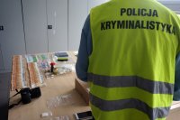 Policjant - technik kryminalistyki podczas wykonywania oględzin.