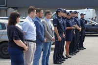 samorządowcy i policjanci stoją w rzędzie podczas przemówienia komendanta