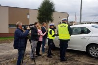 Policjanci i dziennikarze rozmawiają z kontrolowanym kierowcom.