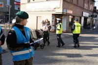 Policjanci i licealiści rozdają odblaski.