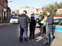 Policjanci i licealiści rozdają odblaski.