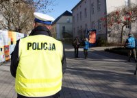 Policjanci i licealiści rozdają odblaski.