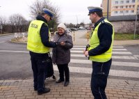 Policjanci wręczają odblask kobiecie.