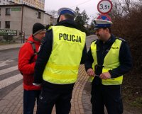 Policjanci z rybnickiej drogówki rozdają odblaski mieszkańcowi miasta.