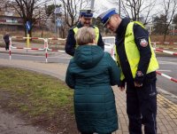 Policjanci z WRD KMP w Rybniku wręczają opaskę odblaskową seniorce.