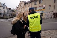 Policjant wręcza młodzieży odblaski.