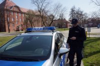 Policjant przy radiowozie podczas kontroli parków.