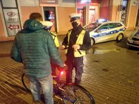 Policjanci ruchu drogowego rozdają odblaski.