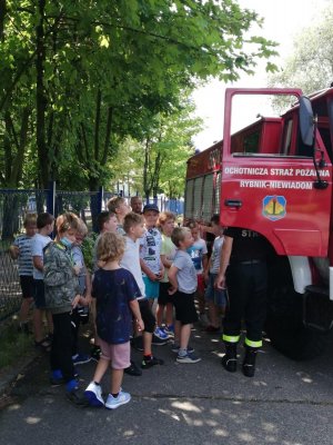 Dzieci oglądają wóz strażacki.