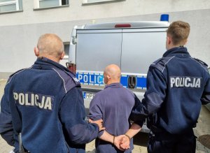 Mężczyzna zatrzymany, podejrzany o usiłowanie zabójstwa doprowadzany przez policjantów do prokuratury.