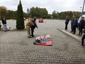 Kurs pierwszej pomocy. Strażak demonstruje, jak udzielić pierwszej pomocy.