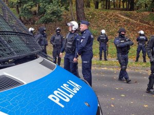 Policjanci zabezpieczają mecz piłki nożnej.