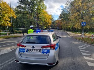 Policyjny radiowóz na sygnałach i policjant ruchu drogowego. Blokowanie ulicy Gliwickiej.