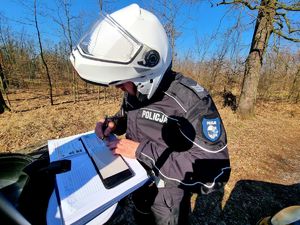 Policjant wypisuje mandat karny.