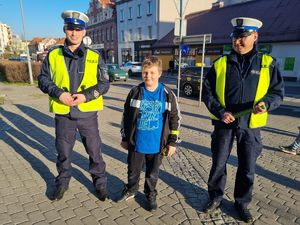 Chłopiec wraz z umundurowanymi policjantami.