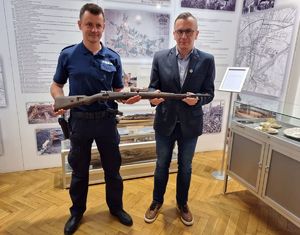 Policjant przekazuje dyrektorowi w Rybniku broń typu mauser.