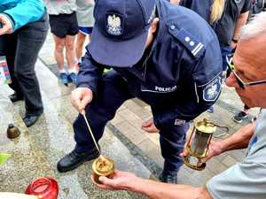 Zastępca Komendanta Miejskiego Policji w Rybniku - młodszy inspektor Roman Chlubek zapala &quot;Ogień Nadziei&quot; pod pomnikiem &quot;Jana Pawła II&quot; w Rybniku.