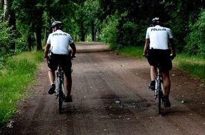 Policjanci na rowerach patrolują tereny leśne.