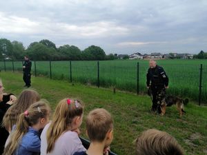 Policjant rozmawia z dziećmi o bezpieczeństwie.