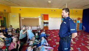 Policjant rozmawia z dziećmi na temat bezpieczeństwa.