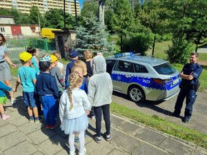 Dzieci w kolejce chcą zobaczyć policyjny radiowóz.