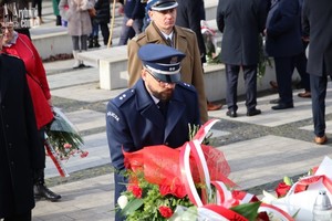 Naczelnik prewencji rybnickiej komendy składa kwiaty przed pomnikiem.