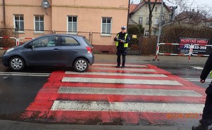 Przejście dla pieszych. Policjanci wykonują czynności na miejscu wypadku drogowego.