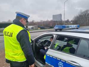 Zastępca Naczelnika Ruchu Drogowego kontroluje policjantów podczas działań.