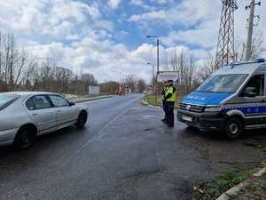 Policjanci obserwują przejeżdżające przez przejazd kolejowy pojazdy