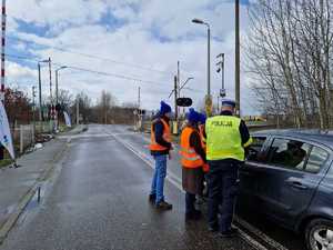 Policjant i pracownicy Kolei Śląskich przypominają zasady bezpiecznego przejazdu przez przejazd kolejowy