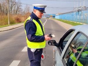 Policjant sprawdza trzeźwość kierującej.