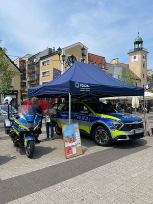 Policyjny namiot profilaktyczny oraz radiowóz i motocykle.