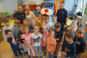Pamiątkowe zdjęcie przedszkolaków z policjantami oraz Sznupkiem.