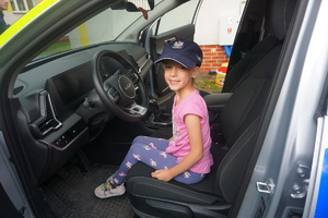 Dziewczynka za kierownicą policyjnego radiowozu.