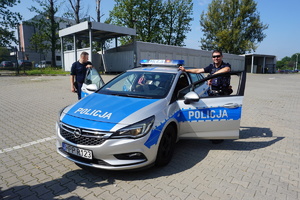 Policjanci prezentują dzieciom oznakowany radiowóz.