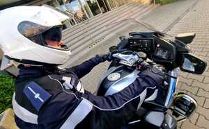 Policjant rozpoczyna służbę na motocyklu.