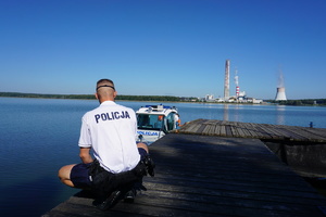 Policjant cumuje łódź policyjną.