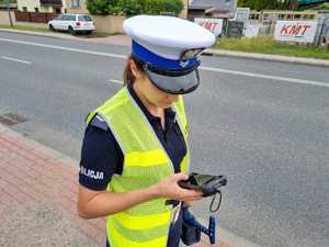 Policjantka sprawdza kierującego w systemie na urządzeniu przenośnym.