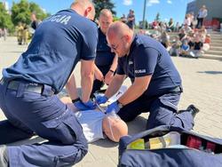 Policjanci udzielają pomocy osobie poszkodowanej.