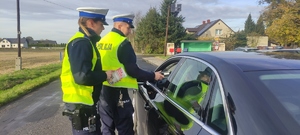 Policjant sprawdza stan trzeźwości kierowcy.